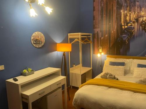 a bedroom with a bed with a desk and a painting at Stenghe Stracche in Ascoli Piceno