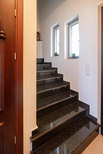a staircase in a house with black marble steps at Villa Athina in Preveza