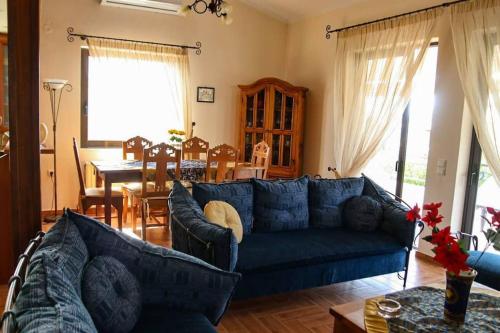 a living room with a blue couch and a dining room at Nice house in Euboea in Politika