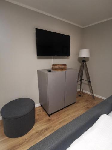 a bedroom with a bed and a tv and a stool at Ferienhaus zur Weinfee in Briedel