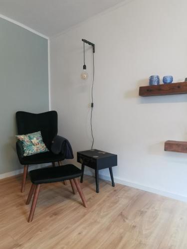a black chair and a table in a room at Ferienhaus zur Weinfee in Briedel