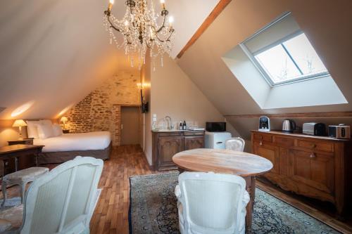 a room with a bed and a table and chairs at Domaine de Charnay Villégiature Sologne in Vierzon