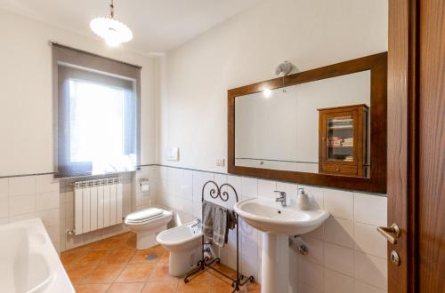 a bathroom with a sink and a toilet and a mirror at casa vacanze Colonnata in Gubbio