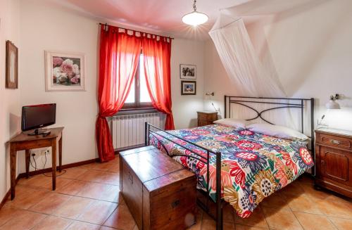 a bedroom with a bed and a television at casa vacanze Colonnata in Gubbio