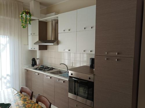 a kitchen with white cabinets and a stove top oven at Casa Betta in Certaldo