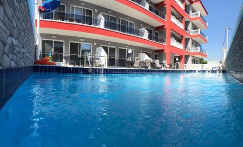 a hotel with a swimming pool in front of a building at Bella Luxury Suite in Paralia Katerinis