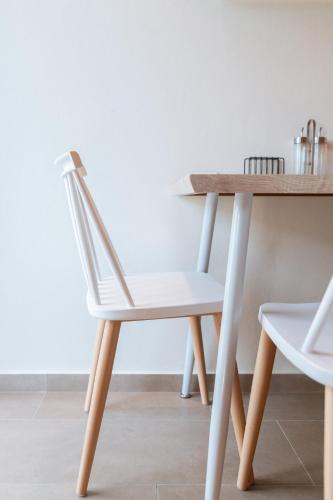 a white chair next to a wooden table at Villa Athina in Preveza