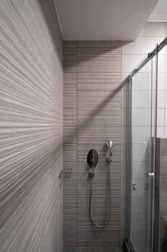 a bathroom with a shower with a glass door at Hotel Sunshine in Kamari