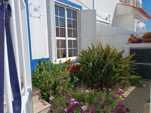 a garden in front of a house with flowers at Alojamento local Família Coelho in Quinta do Conde
