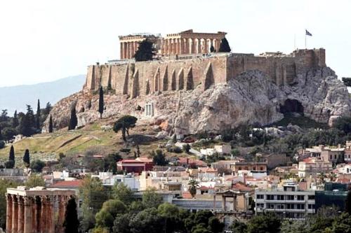 uma cidade com um castelo no topo de uma colina em Экскурсии в Афинах Гид Афины em Atenas