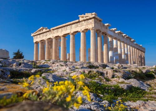 um templo no topo de uma colina com flores em Экскурсии в Афинах Гид Афины em Atenas