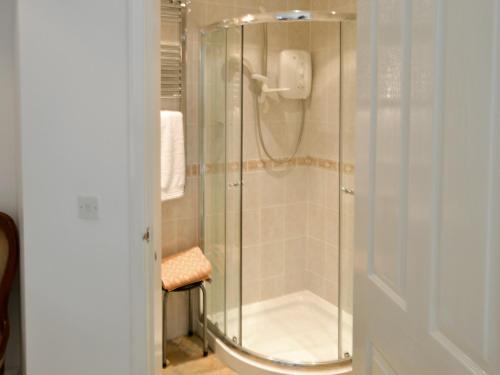 a shower with a glass door in a bathroom at Gamekeepers Cottage in Middleton