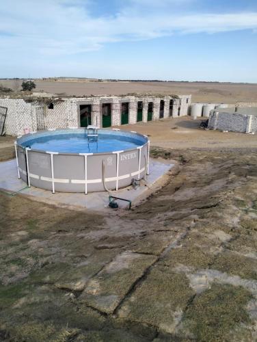 un edificio con piscina en medio de un campo en Golden area farm, en Hurghada