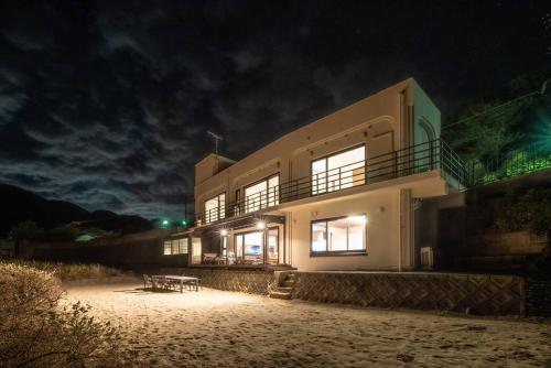 a building on the beach at night at BLUE ARK in Izu