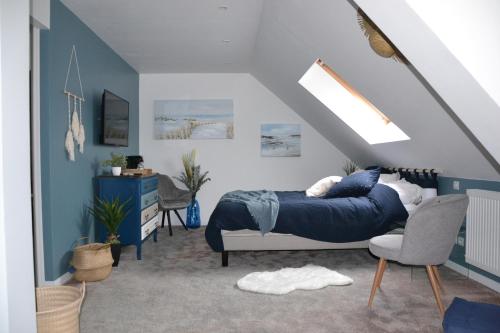 een slaapkamer met een blauw bed en een stoel bij L'Auberge de Vauclair in Bouconville-Vauclair