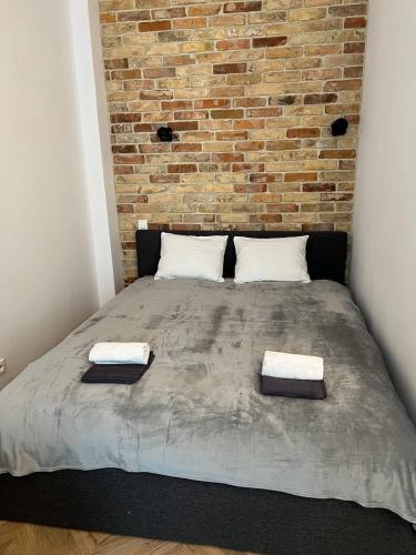 a large bed in a room with a brick wall at Luxury Apartment In The City Center , Wi-Fi - by HIK Apartments in Warsaw