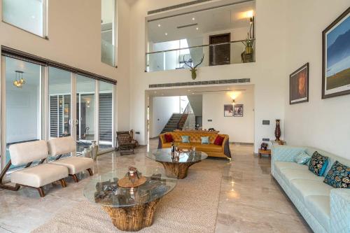 a living room with a couch and a table at StayVista at The Francolin Farm with Free Breakfast, Infinity Pool & Jacuzzi in Sohna