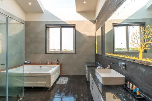 a bathroom with a tub and a sink and a shower at StayVista at The Francolin Farm with Free Breakfast, Infinity Pool & Jacuzzi in Sohna