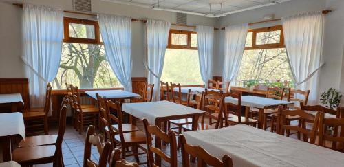 a dining room with tables and chairs and windows at Hotel Capitán in Cangas de Onís