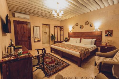 a bedroom with a bed and a table and a couch at Peristyle Cave Cappadocia- Special Class in Uçhisar