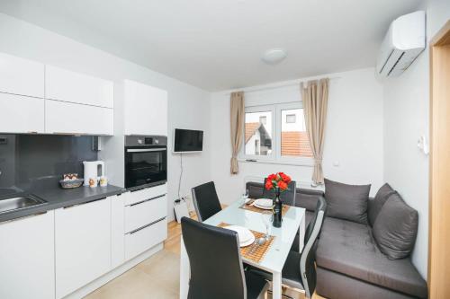 a kitchen and living room with a table and a couch at New & Modern smart HOME, FREE parking in Zagreb