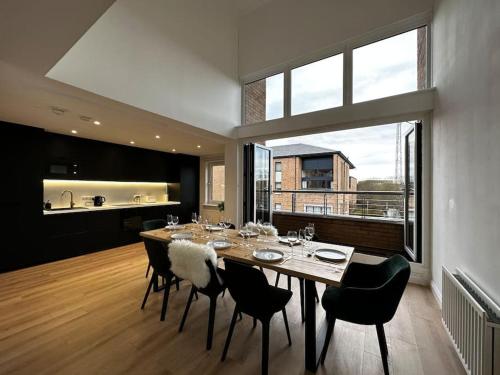 een eetkamer met een tafel en stoelen en een keuken bij 3 Bedroom/3 Bathroom Large Flat Near OVO Hydro in Glasgow