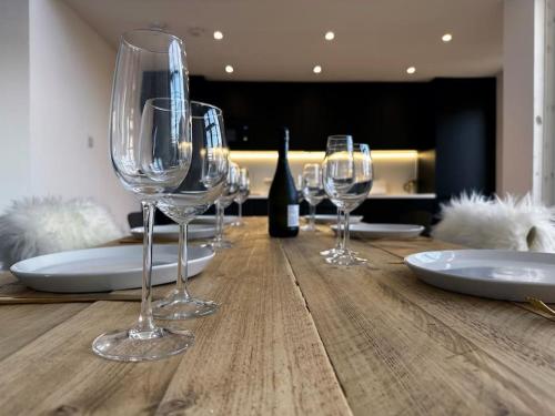 a table with wine glasses and a bottle of wine at 3 Bedroom/3 Bathroom Large Flat Near OVO Hydro in Glasgow