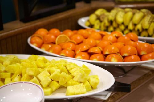 two plates of fruit on a table with plates of oranges at Pacific Hotel Okinawa in Naha