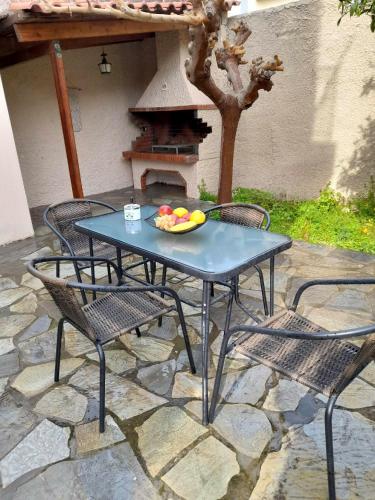 a table and chairs with a bowl of fruit on it at Anna's House in Anavissos