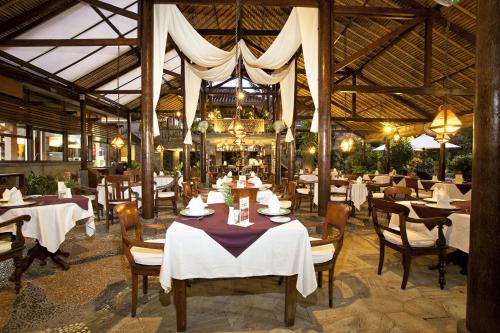 a dining room with tables and chairs in a restaurant at Tamukami Hotel in Sanur