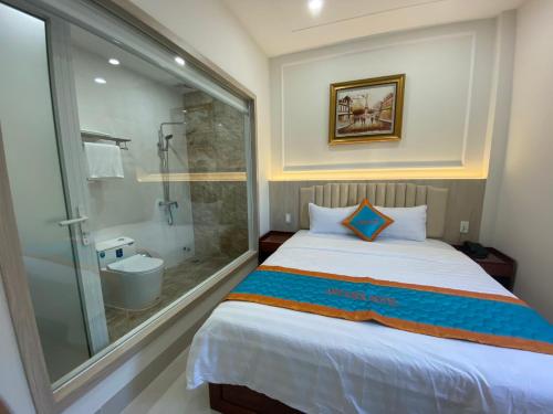 a bedroom with a large bed and a shower at KHÁCH SẠN Biển Xanh in Kinh Dinh