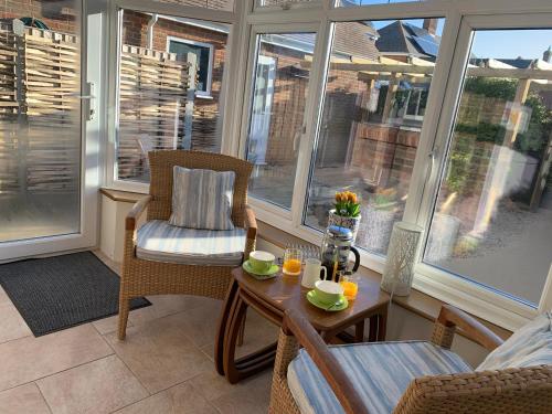 a screened in porch with a table and chairs at The Beach House in Bridport