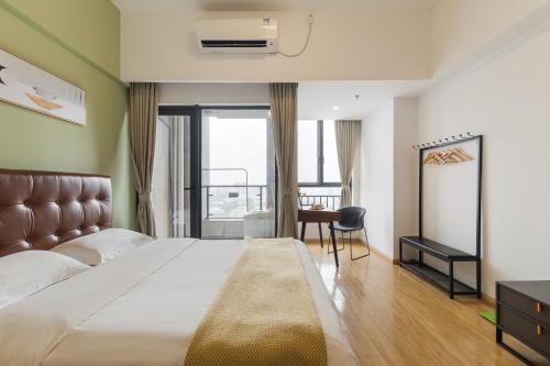 a bedroom with a bed and a desk and a window at Livetour Hotel Shenzhou Road Metro Guangzhou in Guangzhou