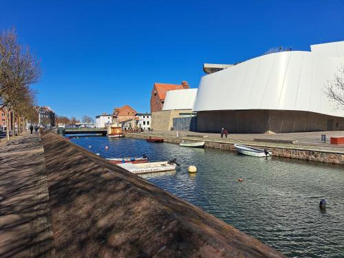 une rivière devant un bâtiment avec des bateaux dans l'établissement Schlafen im Hafen Stralsund, à Stralsund