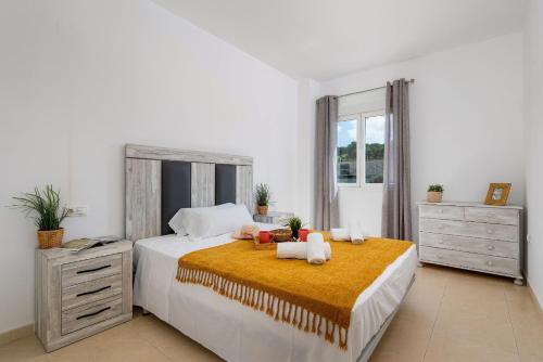 a bedroom with a large bed with two towels at Apartment Happy - PlusHolidays in Calpe