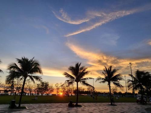 a group of palm trees on a beach at sunset at BREAKING DAWN- TAEYANG Hotel Phú Quốc in Phu Quoc