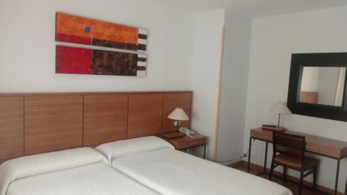 una camera con letto, scrivania e specchio di Molino a Ronda