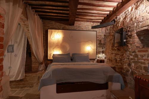 een slaapkamer met een groot bed in een bakstenen muur bij La Casina Del Lillotatini in Panicale