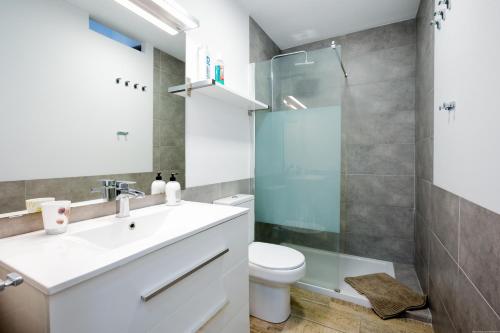 y baño con aseo, lavabo y ducha. en Luxury Apartment en Adeje