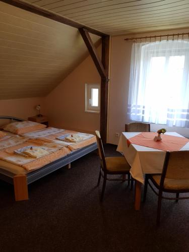 1 dormitorio con 1 cama, mesa y sillas en Guest House Pod Lesem Merklín, en Merklín