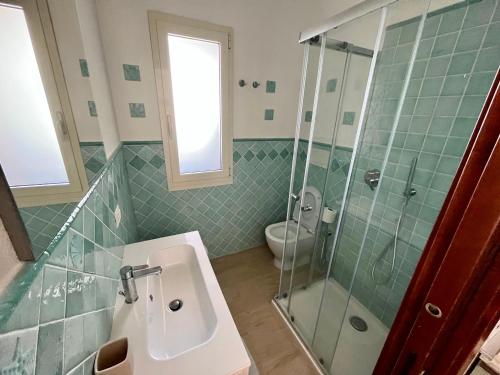 a bathroom with a sink and a shower and a toilet at Pinus Village Apartments 4 vista mare in Forte Village