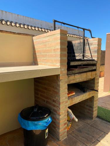 a backyard chicken coop with a brick wall and a trash can at Apartamentos Turísticos Carmencita in Bolonia
