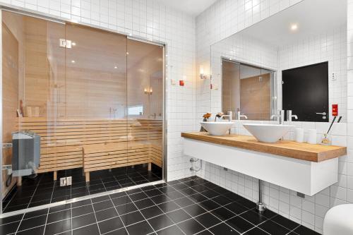 een badkamer met twee wastafels en een douche bij Oceanfront penthouse duplex wamazing view! in Tromsø