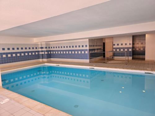 une grande piscine avec de l'eau bleue dans l'établissement L'Etoile d'Orcières Merlette - Au pieds des pistes, à Orcières