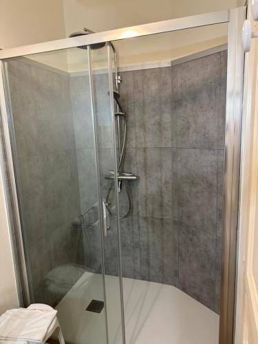 een douche met een glazen deur in de badkamer bij Chambres d'hôtes du puy d'anché in Sauzé-Vaussais