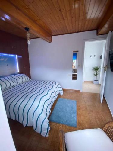 1 dormitorio con 2 camas y techo de madera en Bueu en Bueu