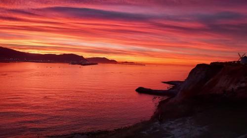 a sunset over a body of water with a cliff at Atxispe Etxea Casa Rural in Laukiz