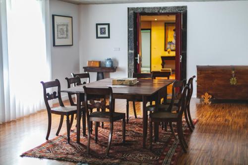 - une salle à manger avec une table et des chaises en bois dans l'établissement Quinta dos Mistérios- Turismo de Habitação, à Fajã de Santo Amaro