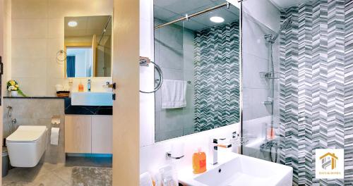 a bathroom with a toilet and a sink and a shower at Hayyak Homes-Luxury 1 bedroom Apartment in Dubai