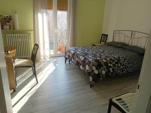 Schlafzimmer mit einem Bett, einem Tisch und einem Fenster in der Unterkunft Casa Leo in Reggio nell'Emilia